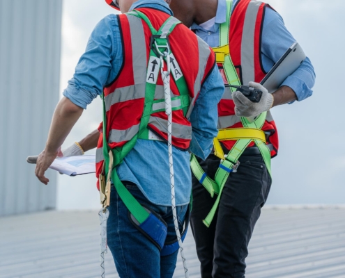 Image of two workers on an industrial roof, looking at a clipboard.