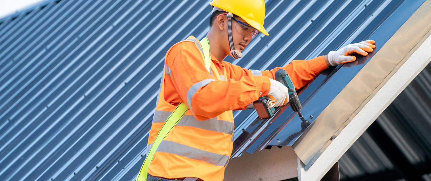 Roofer working on roof structure of building on construction site