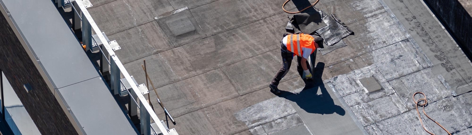 Image of a roofer fixing a flat roof.