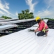 Image of a worker installing a metal commercial roof.