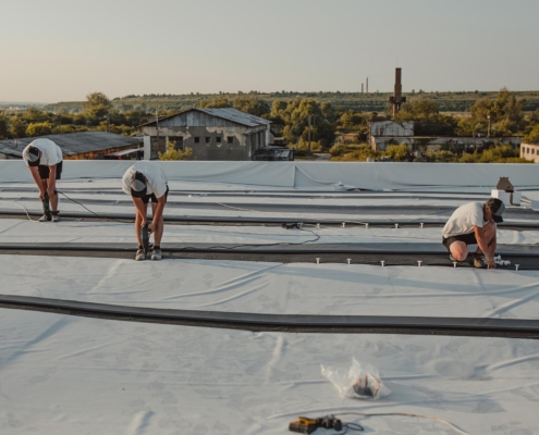 Image of workers repairing a commercial roof.