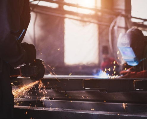 Side view of two workers welding