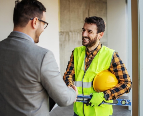 Business person shaking hands with roofer