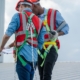 Two professional roofers with clipboard inspecting commercial roof