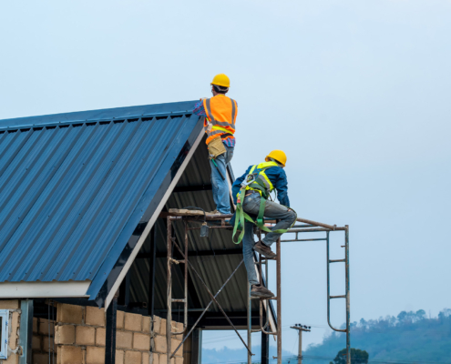 Construction worker using nail gun to install new roof