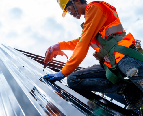 Roofer working on roof structure of building on construction site
