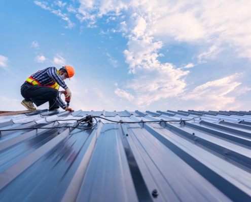 worker repairing metal roof