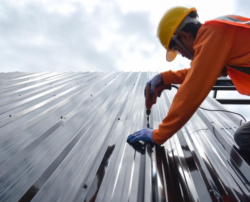 Worker installing metal roof