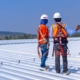 Two workers inspecting metal roof