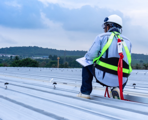 worker inspects metal roof