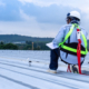 worker inspects metal roof