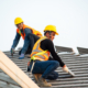 Construction worker using nail gun to install new roof on top roof